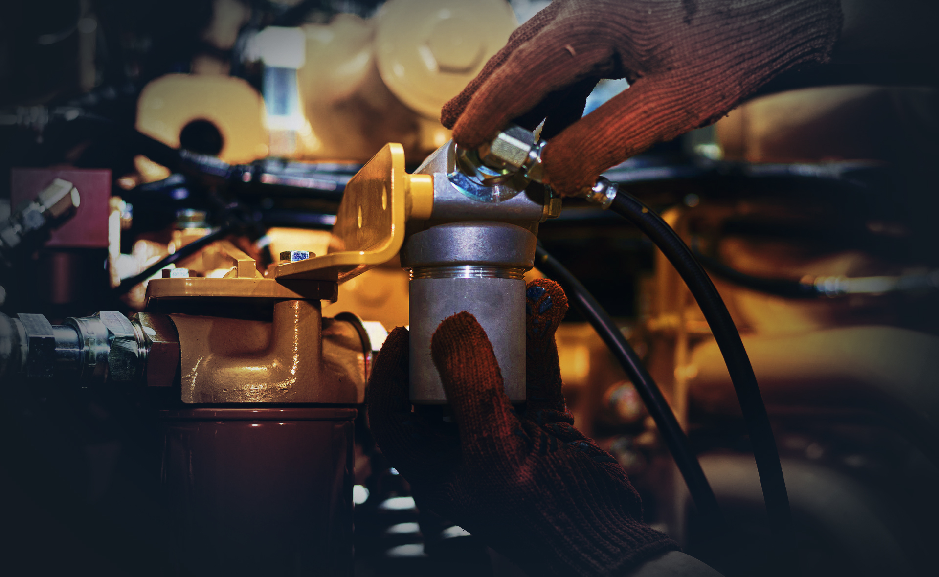 Hände in Arbeitshandschuhen bearbeiten ein Bauteil an einer Baumaschine – Beispiel für den professionellen Baumaschinenservice von Emil Steinebach GmbH, Fachwerkstatt für Nutzfahrzeuge und Baumaschinen.